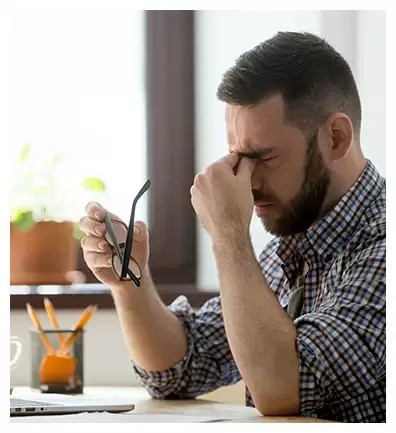 a frustrated person rubbing his eyes