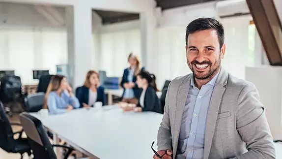 a guy in forma clothes smiling to camera